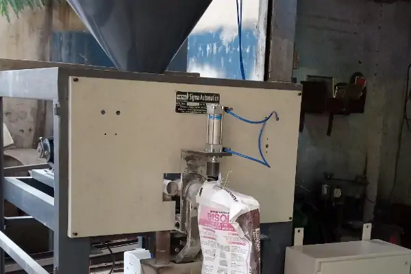 تصویر یک دستگاه کیسه پرکن سیمان روتاری در حال کار در یک کارخانه