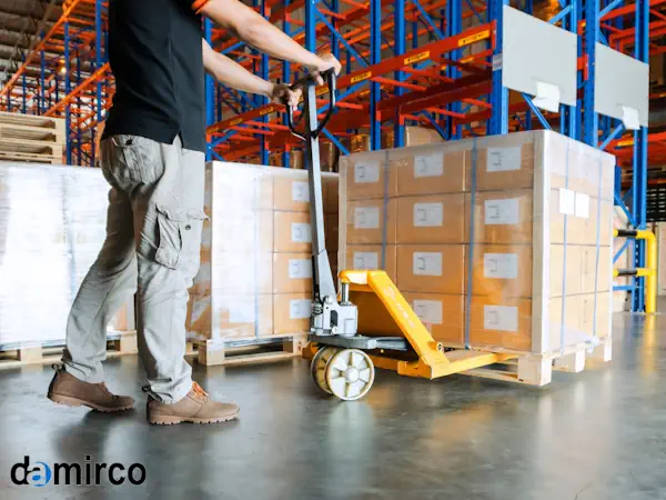 اپراتور در حال جابجایی بار با جک پالت دستی در انبار با رعایت نکات ایمنی